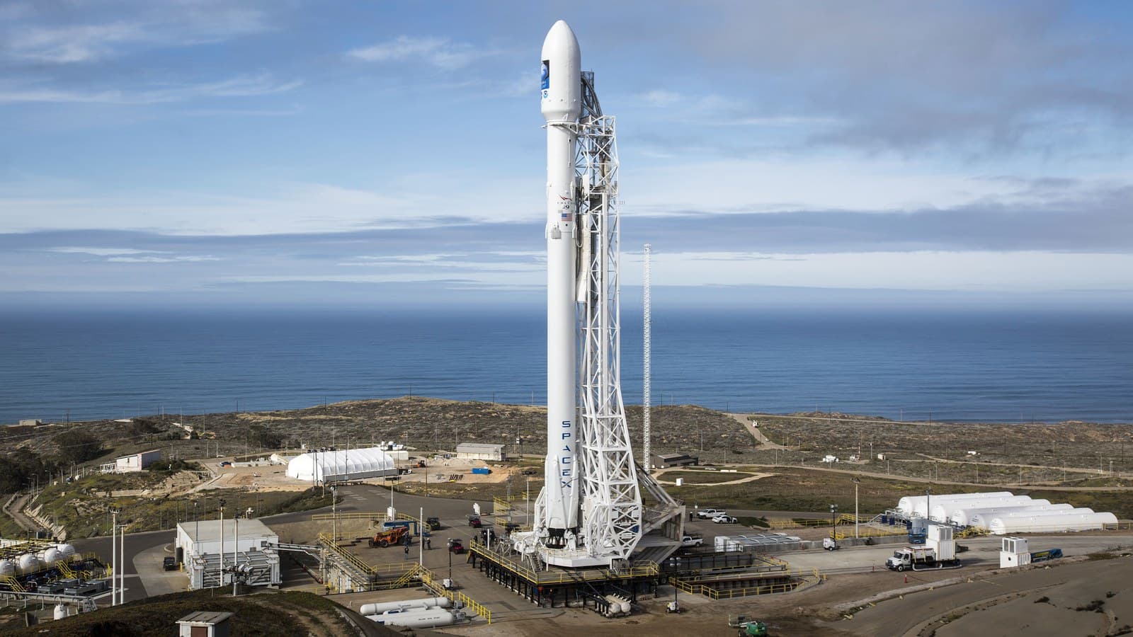 A Falcon 9 rocket stands on its launch pad above the Pacific Ocean at Vandenberg