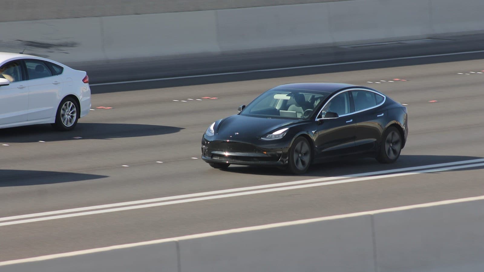 A black Tesla Model 3 driving on U.S. 95 in Las Vegas