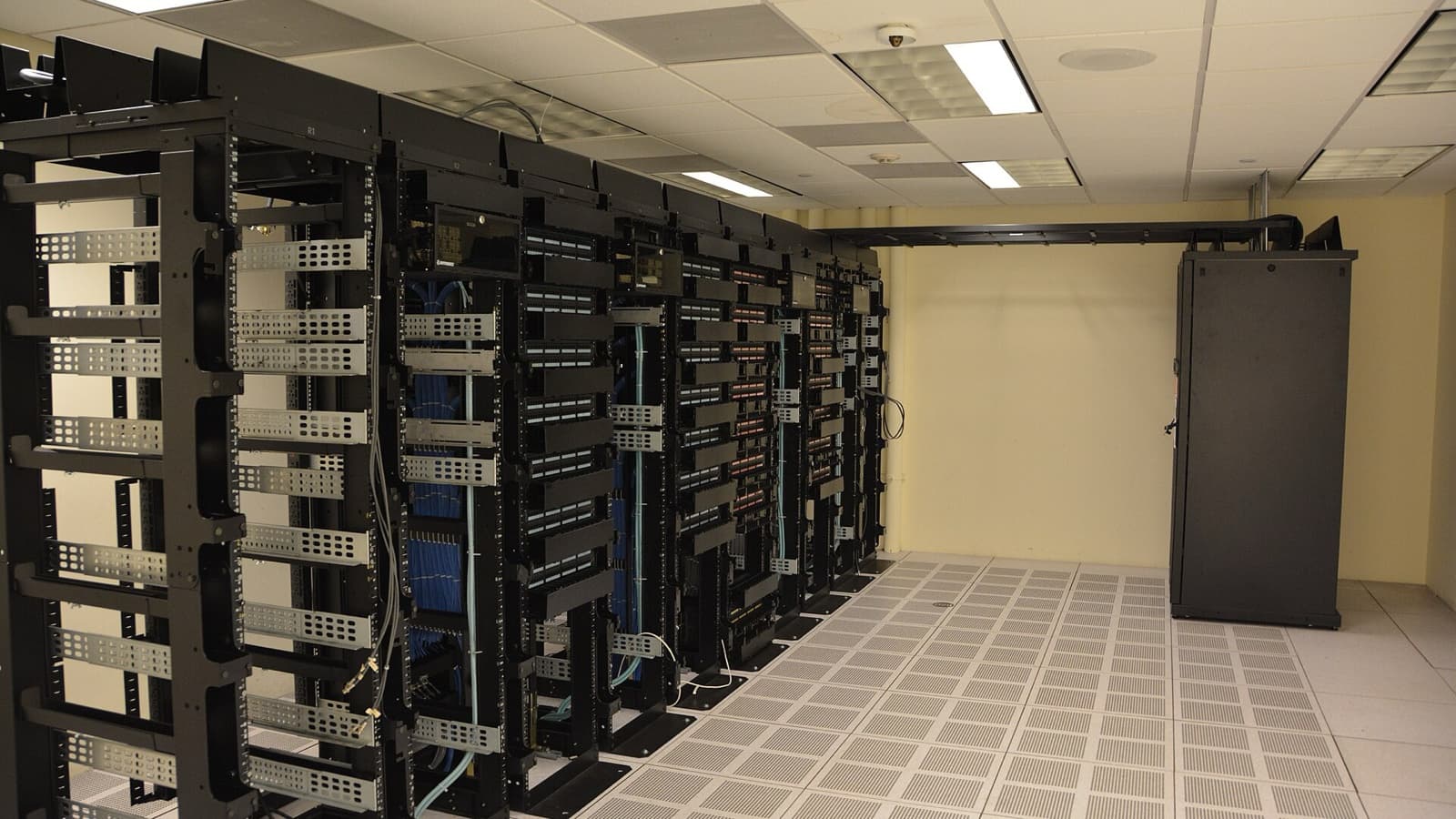 Rows of server racks inside a working data centre, illustrating the infrastructure behind AI cloud computing.