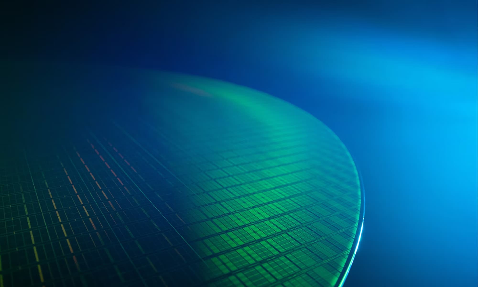 Close-up official Micron image of semiconductor wafer patterns in cool blue and copper tones.