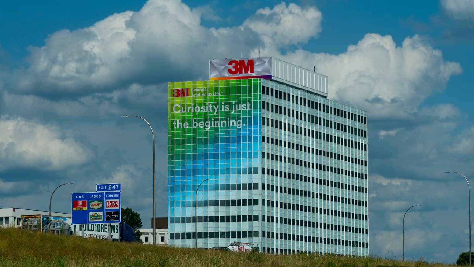 The 3M corporate headquarters building in Maplewood, Minnesota, under a cloudy blue sky