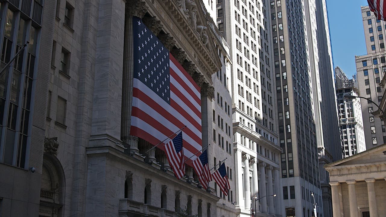 New York Stock Exchange facade with U.S. flags on Wall Street