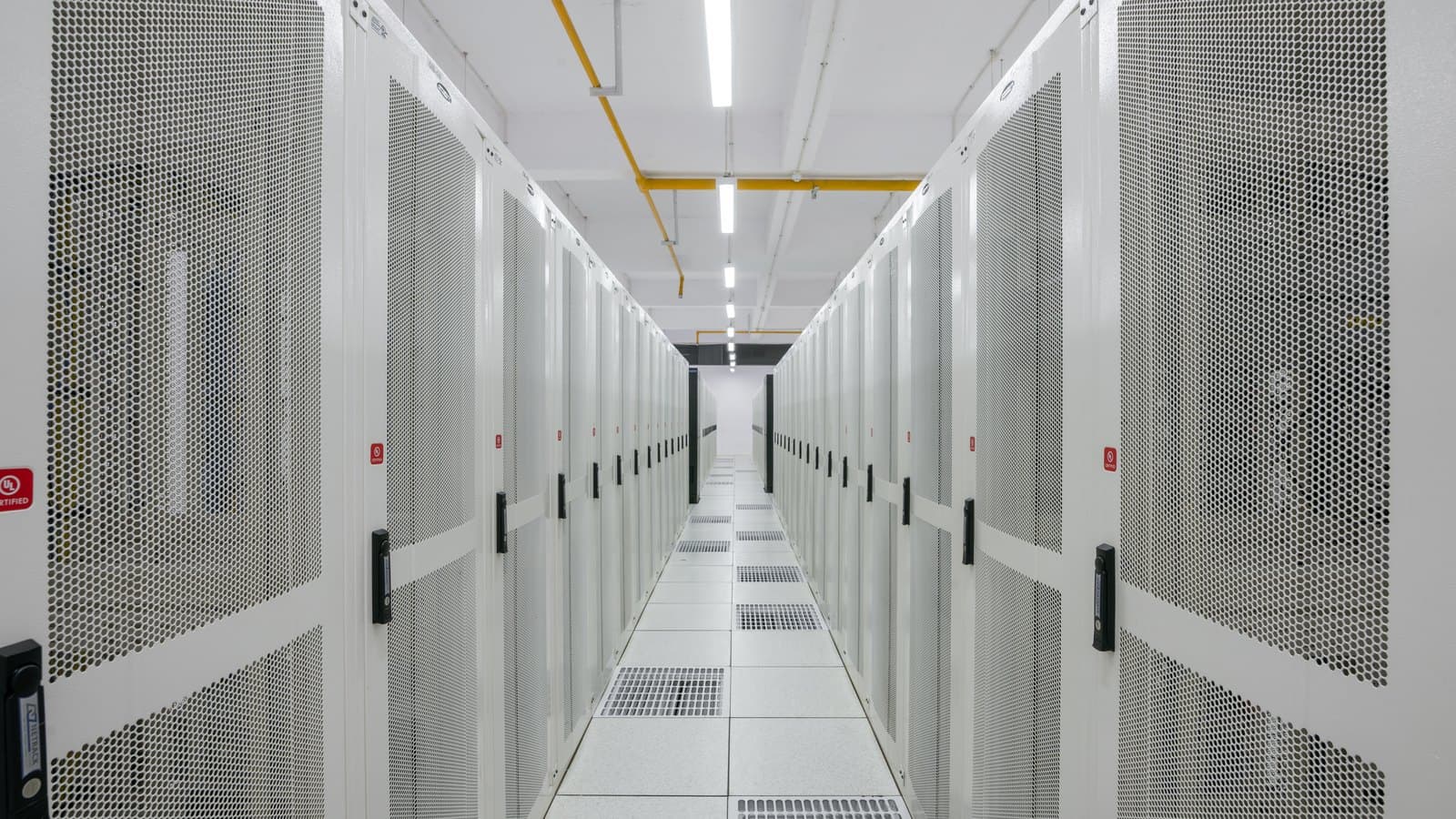 A bright data-centre aisle lined with white server racks