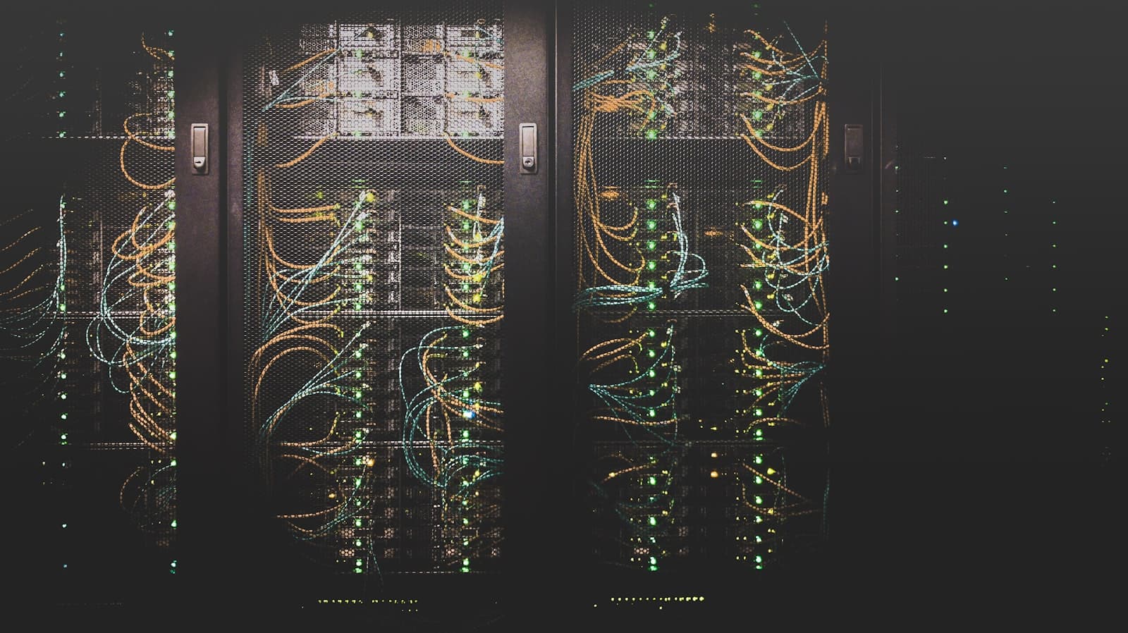 Rows of data-center server racks glowing with status lights and network cabling