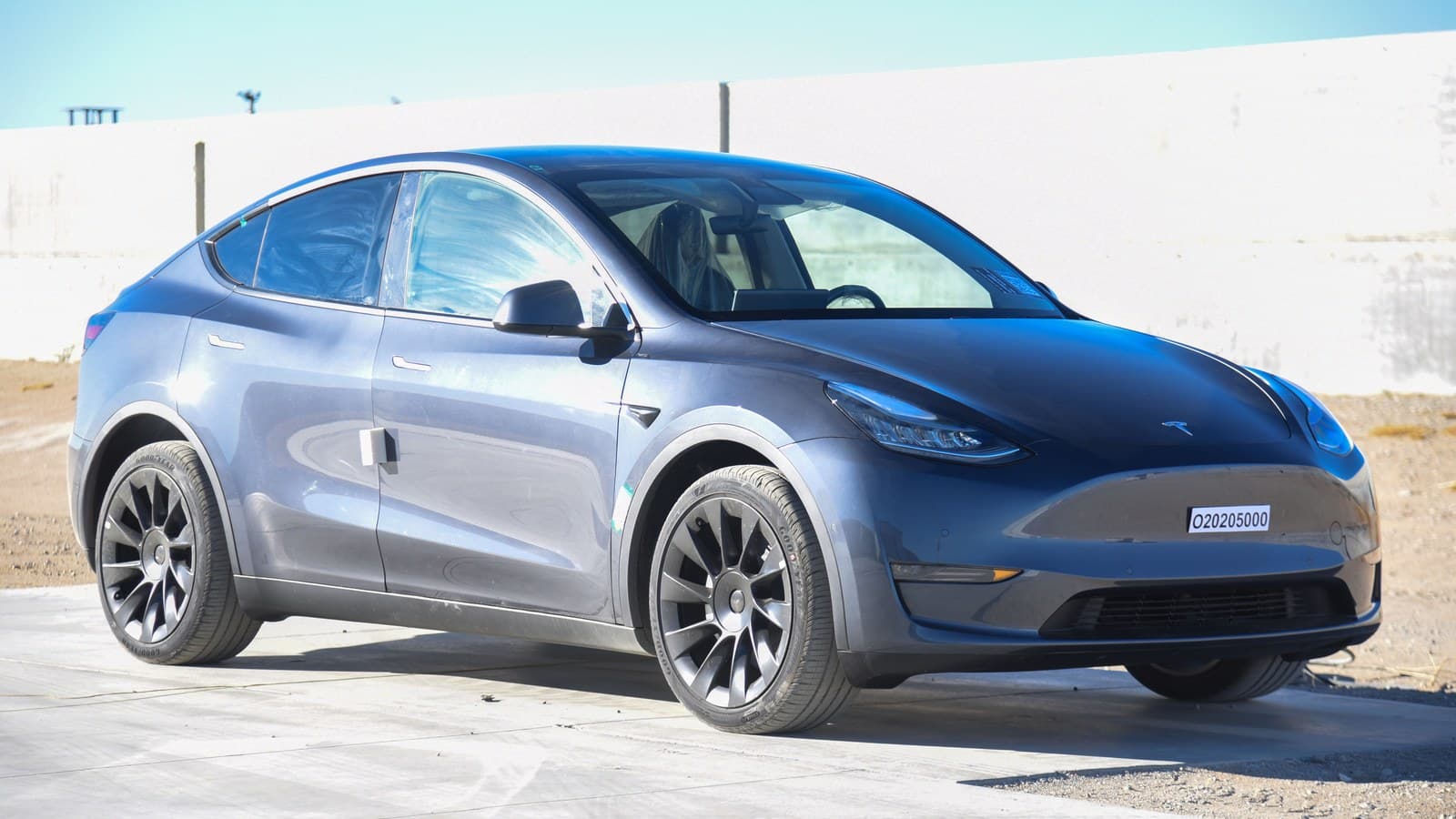 A blue Tesla Model Y photographed outdoors from the front-left side
