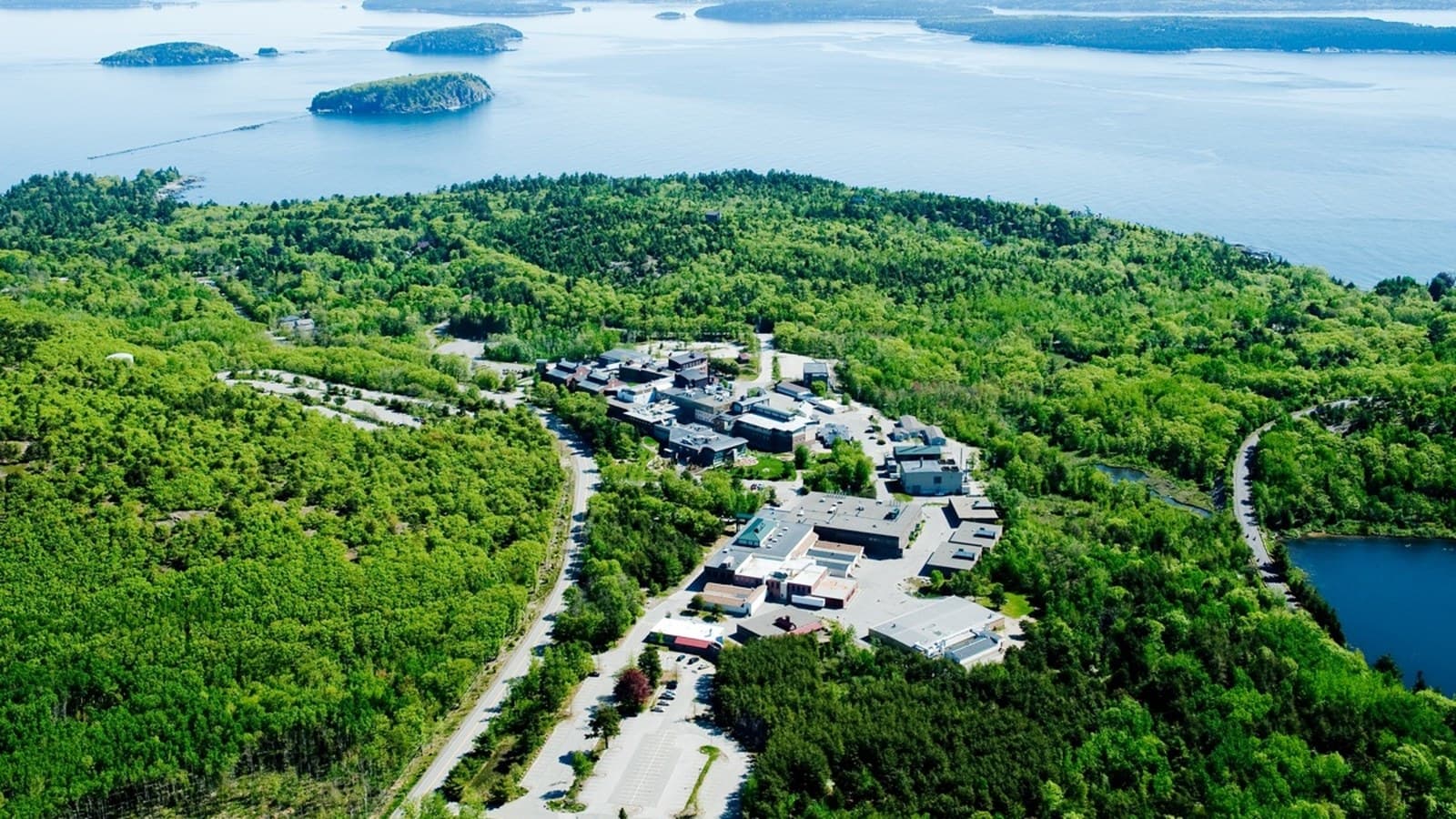 Aerial view of The Jackson Laboratory biomedical research campus beside Frenchman Bay in Maine