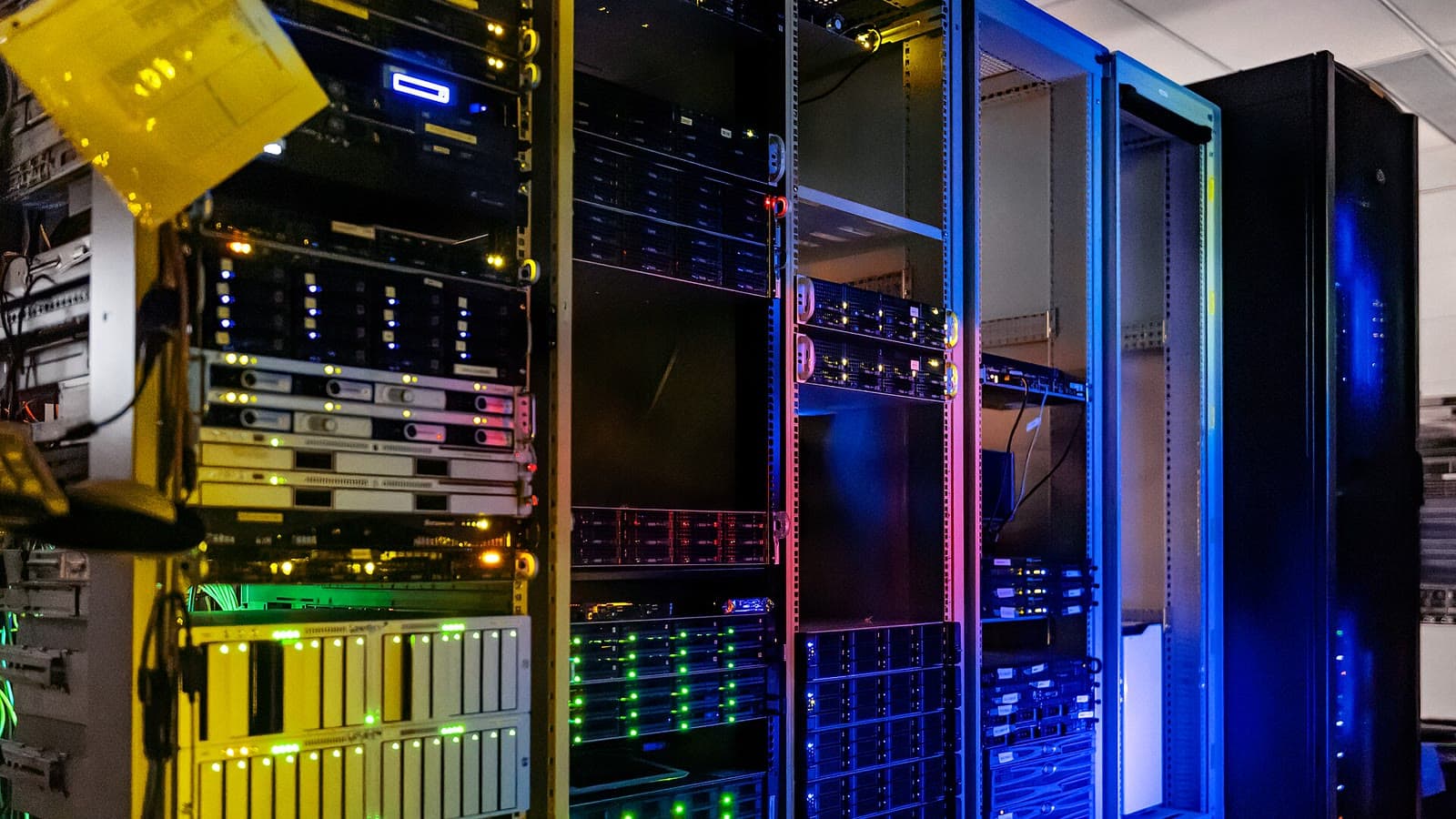 Des rangées de serveurs informatiques éclairés dans le centre de données du siège de NOIRLab à Tucson