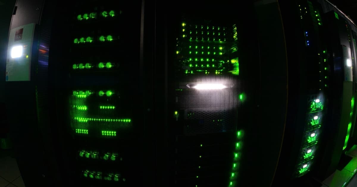 Illuminated server racks inside the DATARMOR high-performance computing and artificial-intelligence data center.