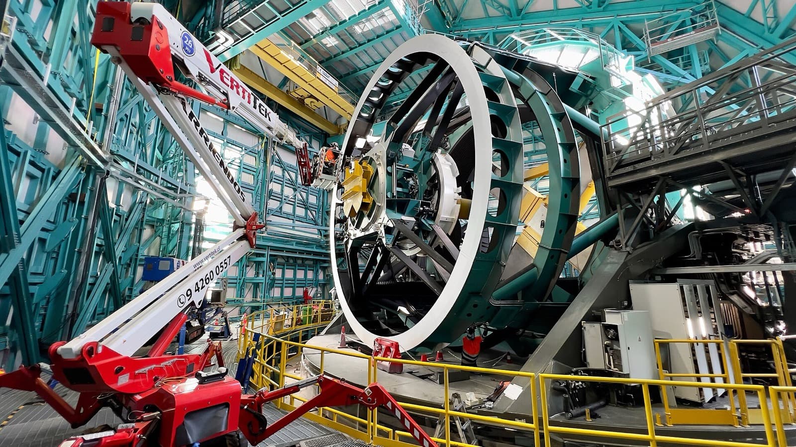 A network technician installs fiber-optic cables on the Rubin Observatory telescope mount