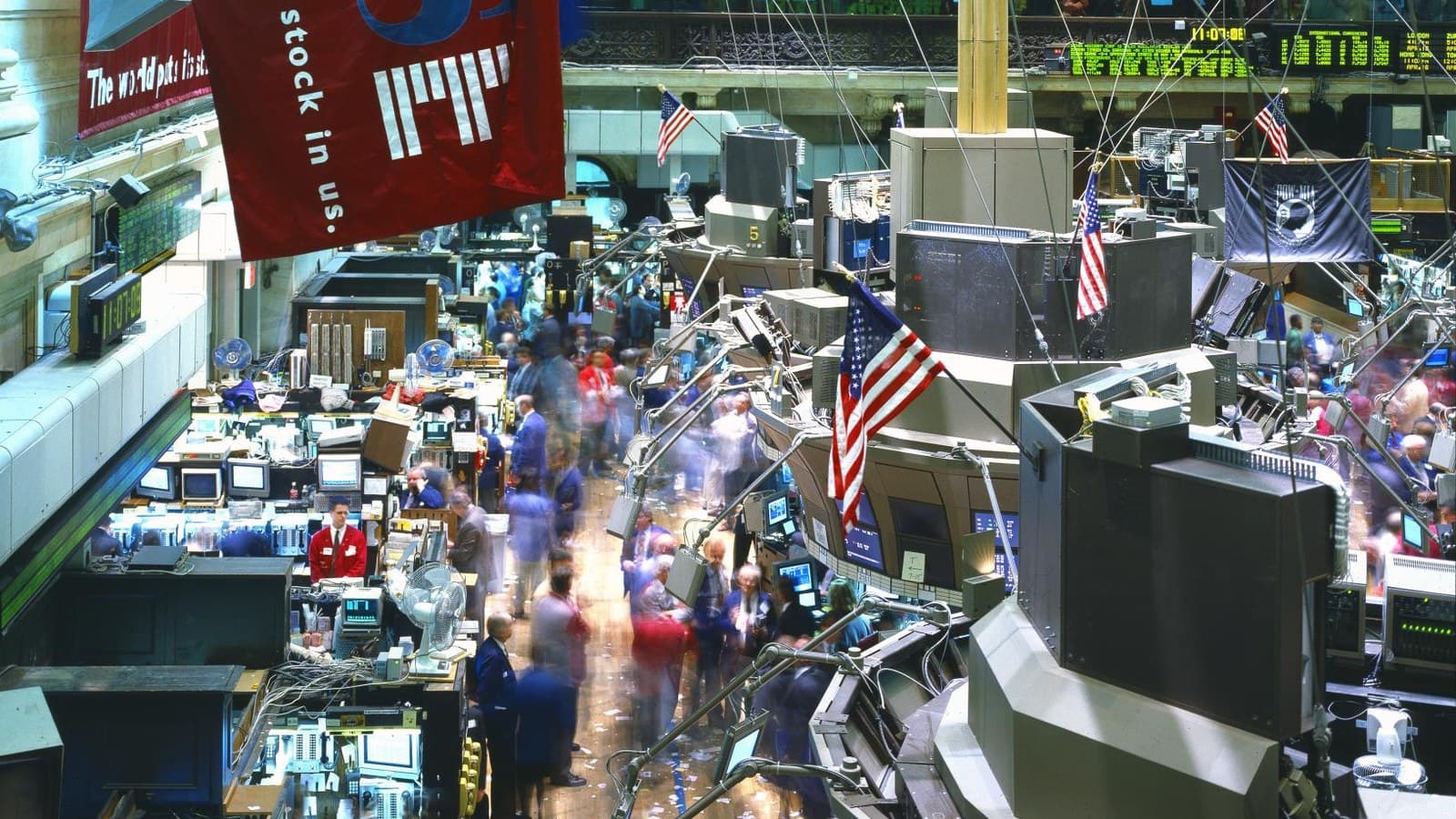 Traders move between crowded workstations and market screens on the New York Stock Exchange floor