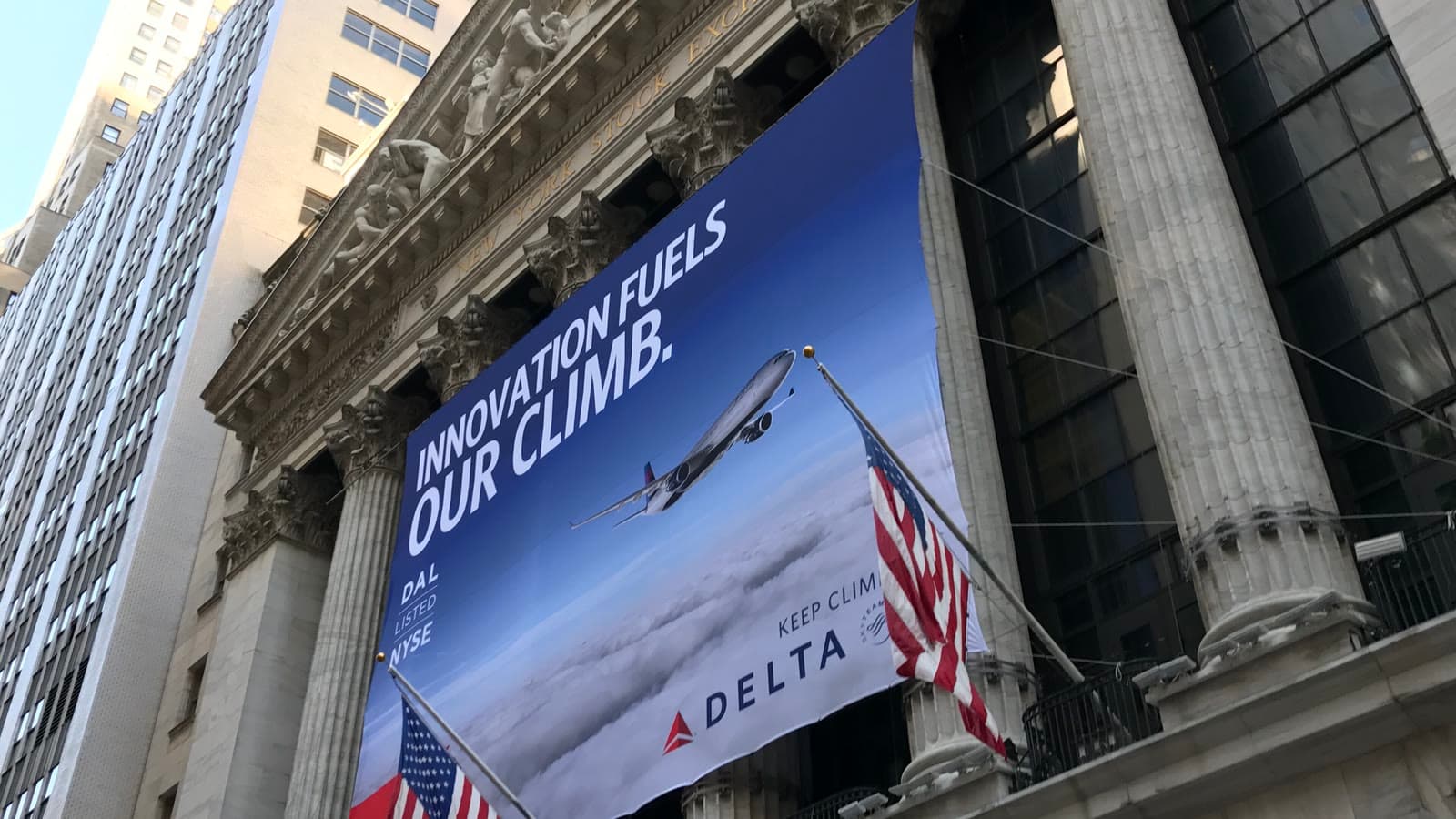 New York Stock Exchange facade with columns, U.S. flags and a Delta listing banner