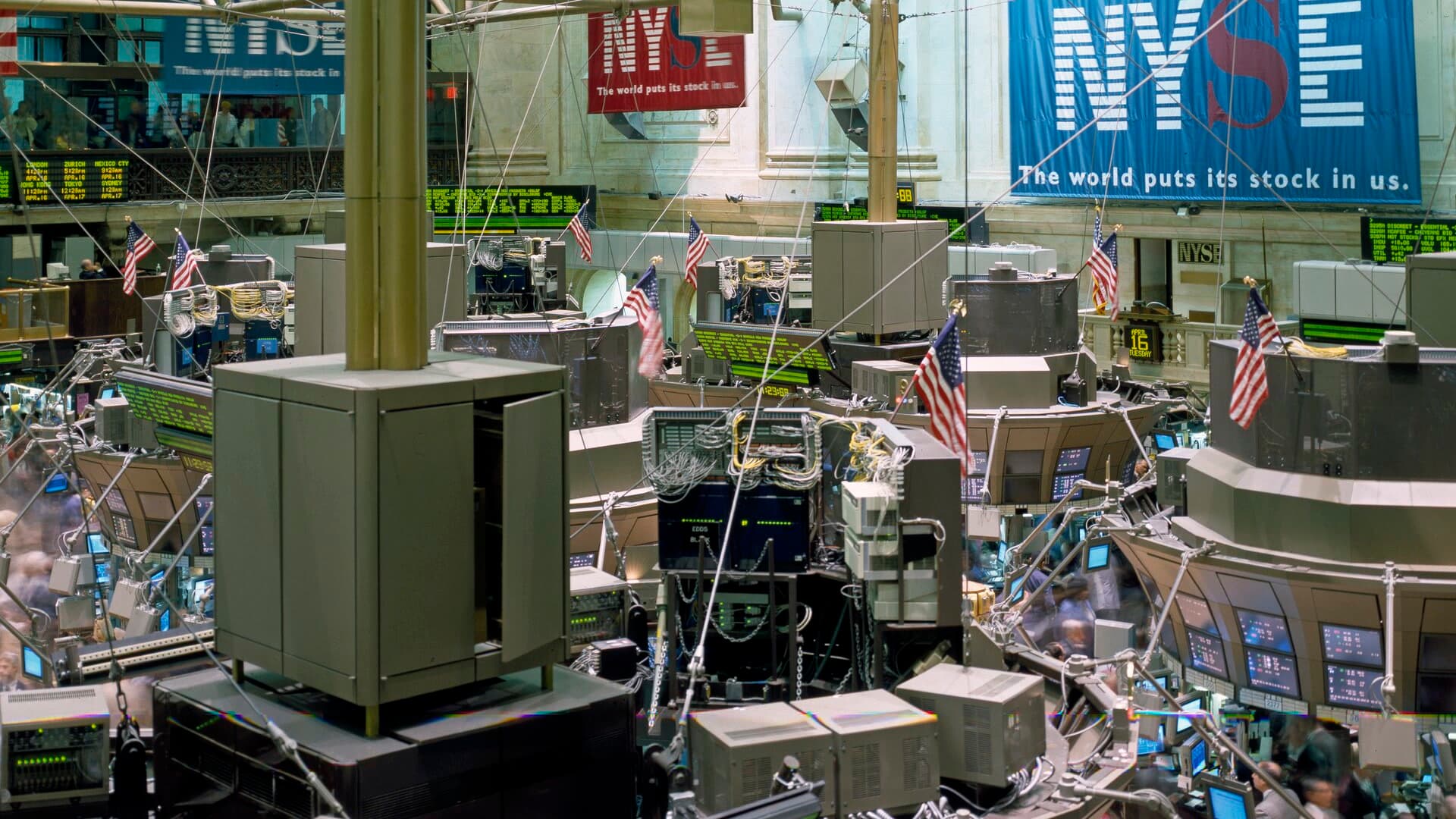 Parquet de la Bourse de New York avec postes de négociation et écrans de marché