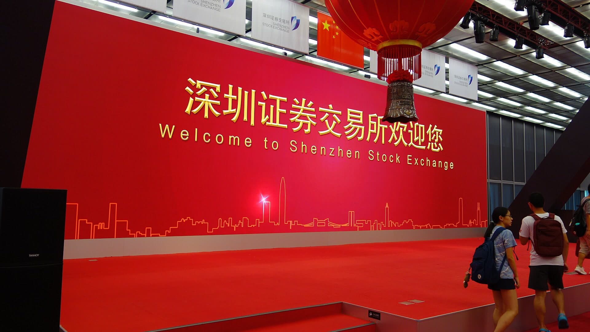 Red welcome wall and ceremonial bell inside the Shenzhen Stock Exchange hall