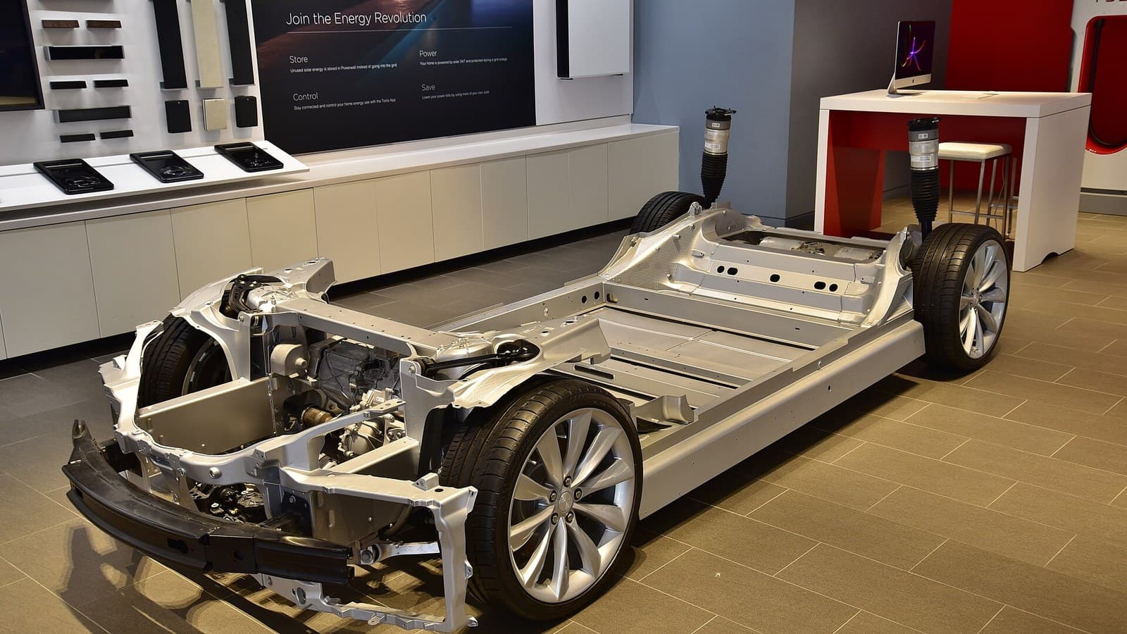 Exposed Tesla electric-vehicle chassis displayed indoors in Sydney