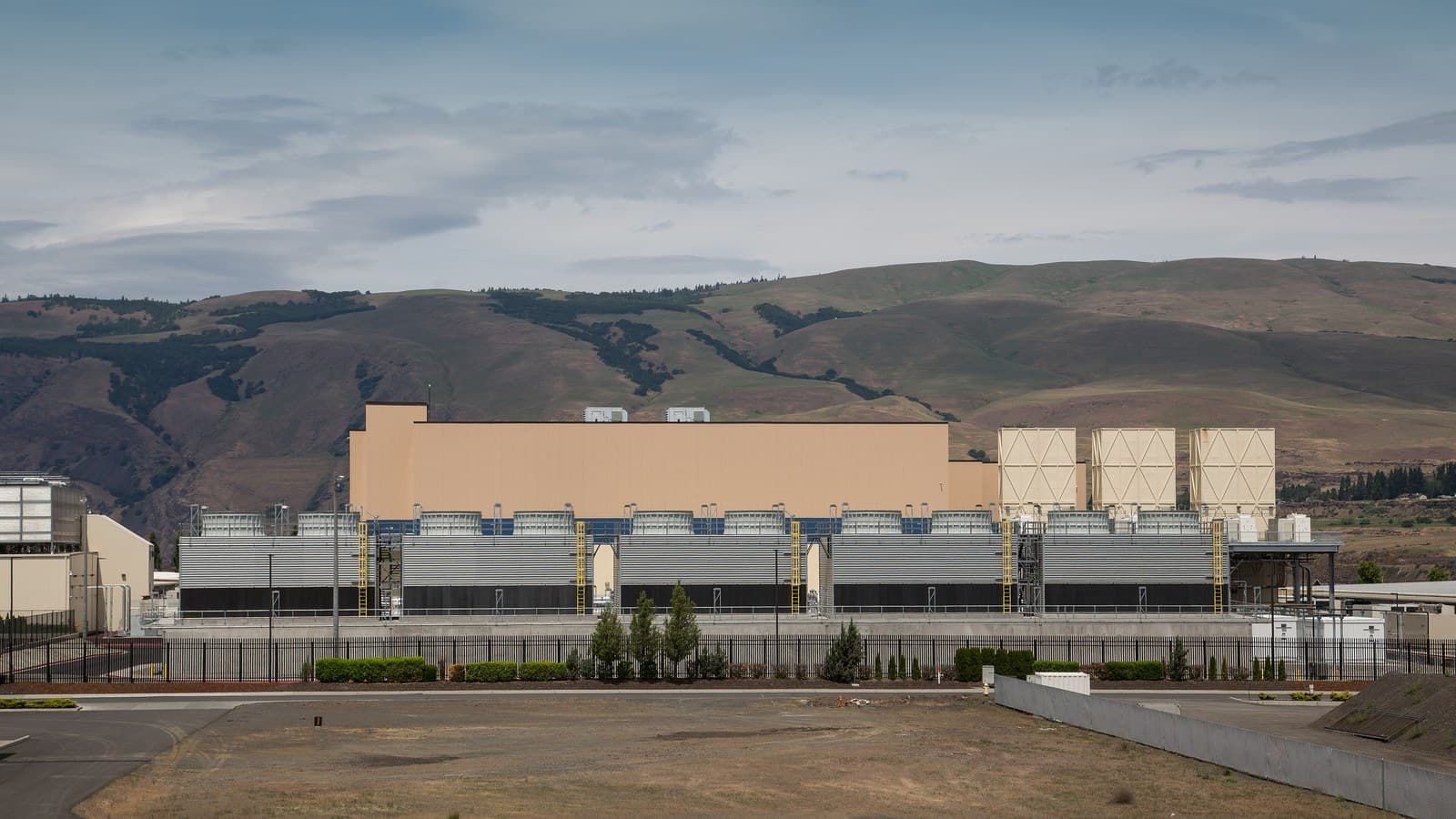 Exterior of Google's data-centre facility in The Dalles, Oregon, with cooling structures and hills in the background